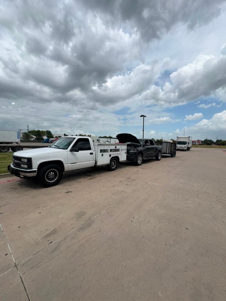 Service truck working on a pickup in a truck stop lot with trailers behind