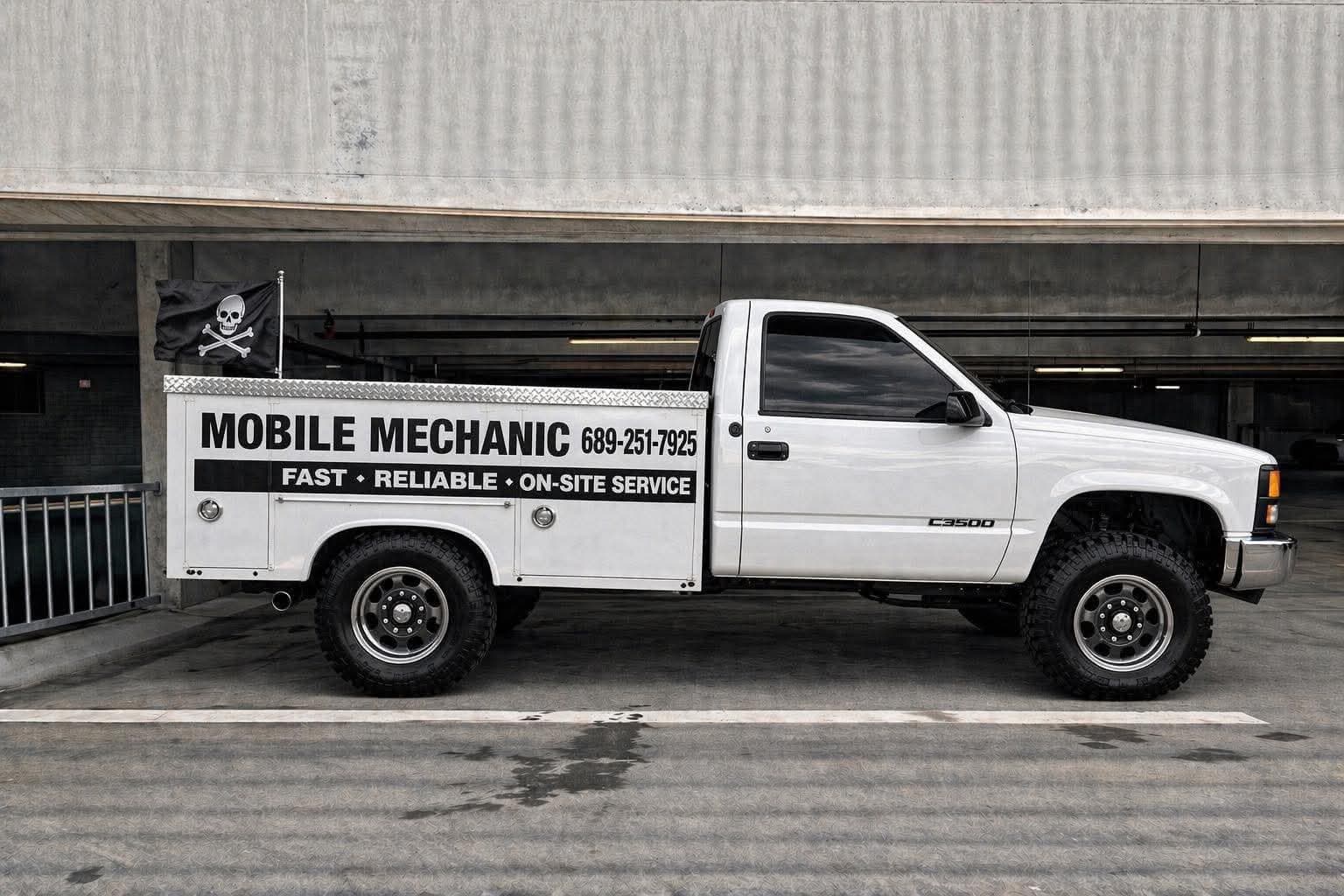 Darlene, a 1990s Chevrolet C3500 service truck with a pirate flag, parked in a concrete garage
